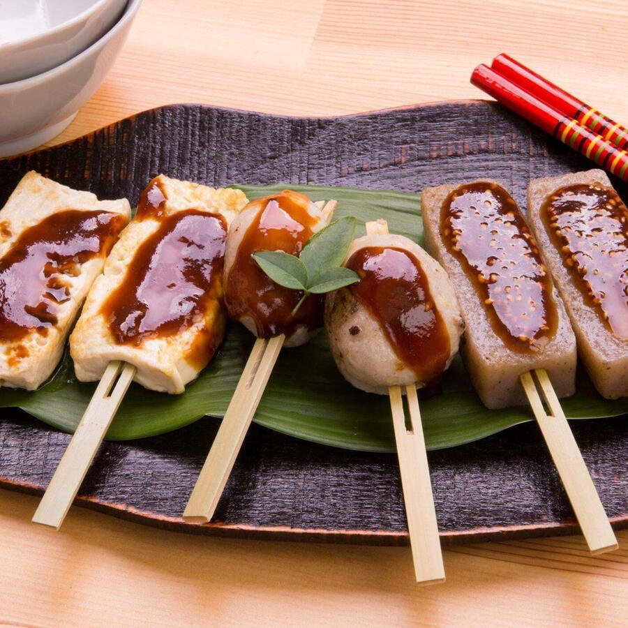 Miso Dengaku Stiff tofu squares and vegetables impaled on a stick and slathered in a sweet miso sauce then roasted over hot coals.